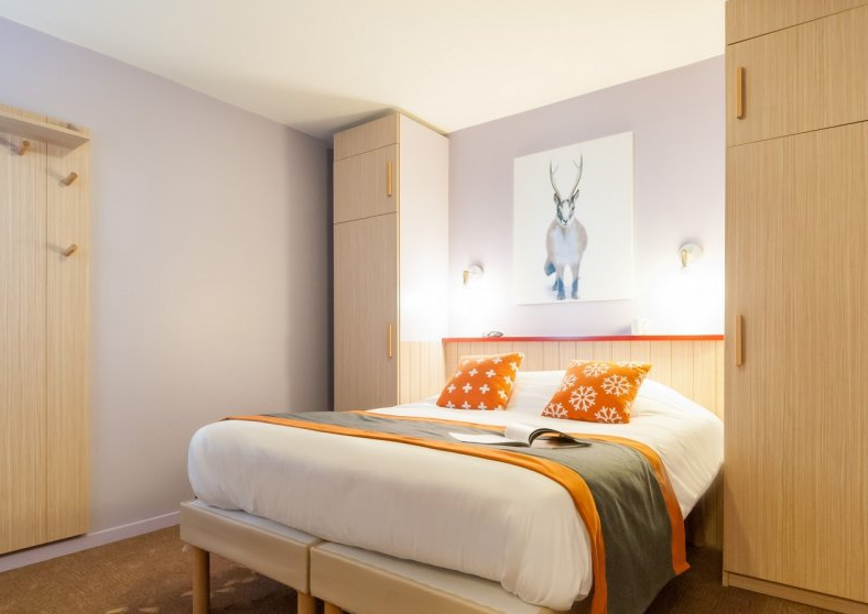 Image of a double bedroom with wardrobes and above bed artwork in Residence Electra Avoriaz