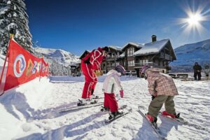 An image of 2 young children at an ESF ski lesson with an instructor