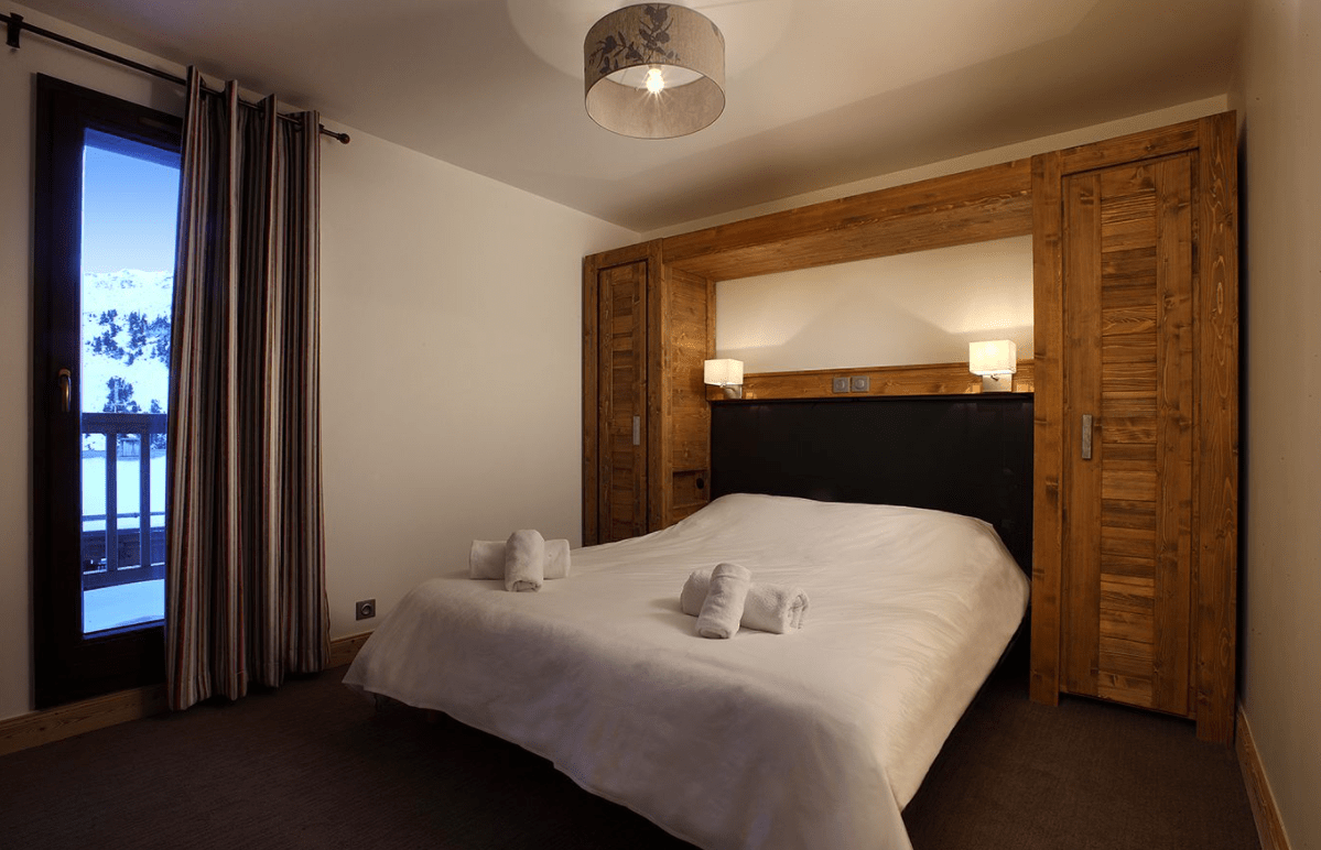 A double bedroom at Residence Chalet des Neiges Arolles