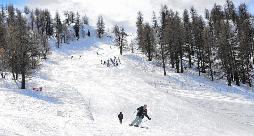 People skiing down a piste in Sauze d'Oulx