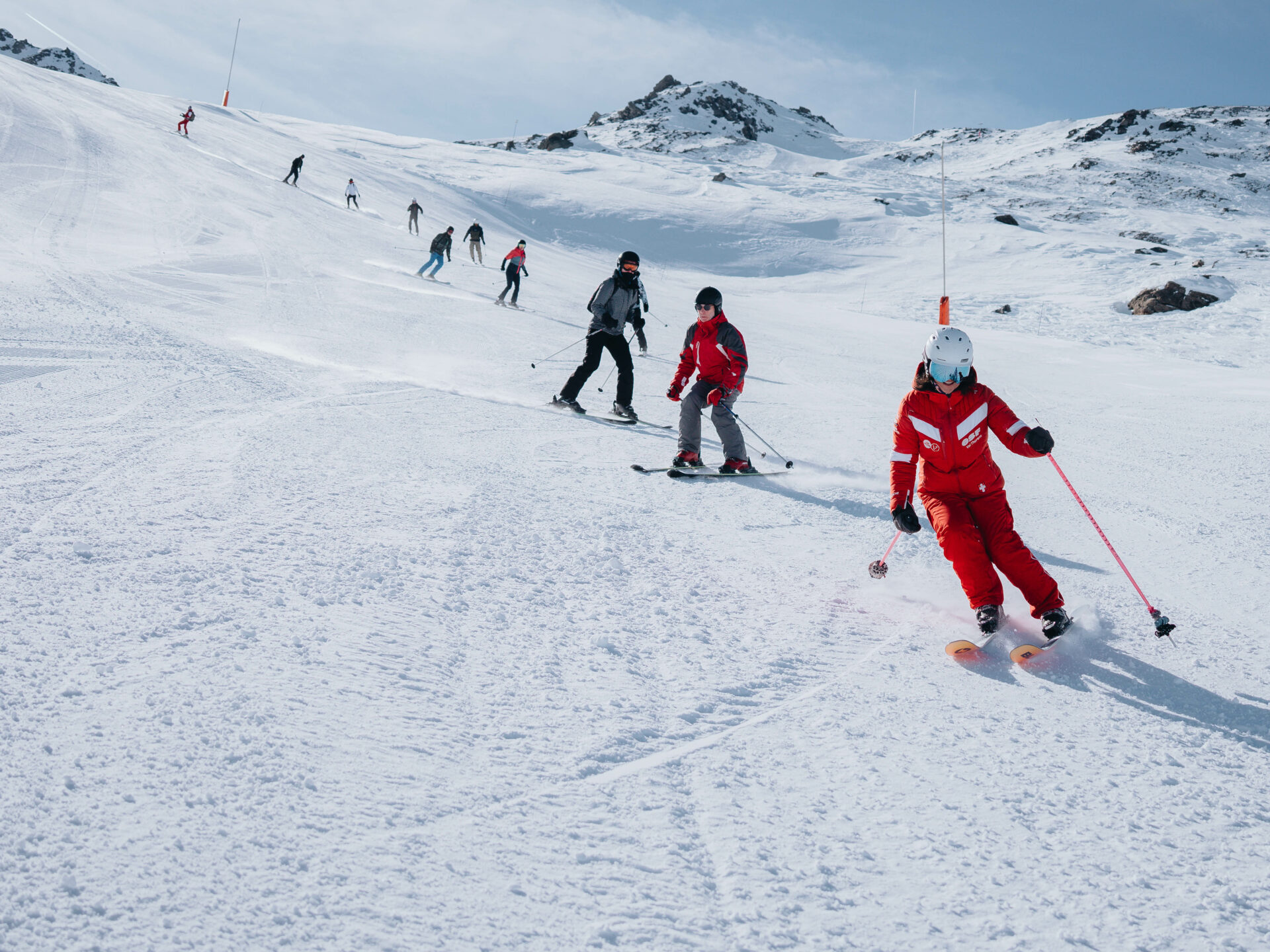 An ESF ski instructor leads skiers down the slopes